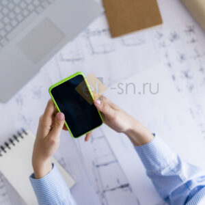 Женщина в офисе работает с проектом на телефоне