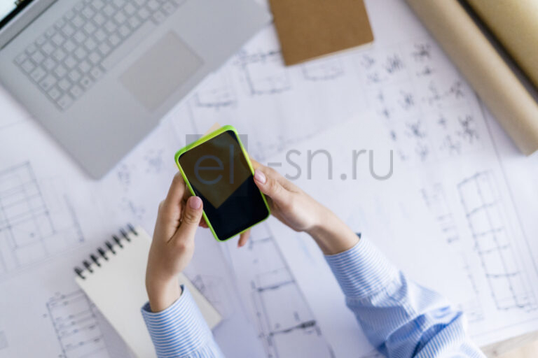 Женщина в офисе работает с проектом на телефоне