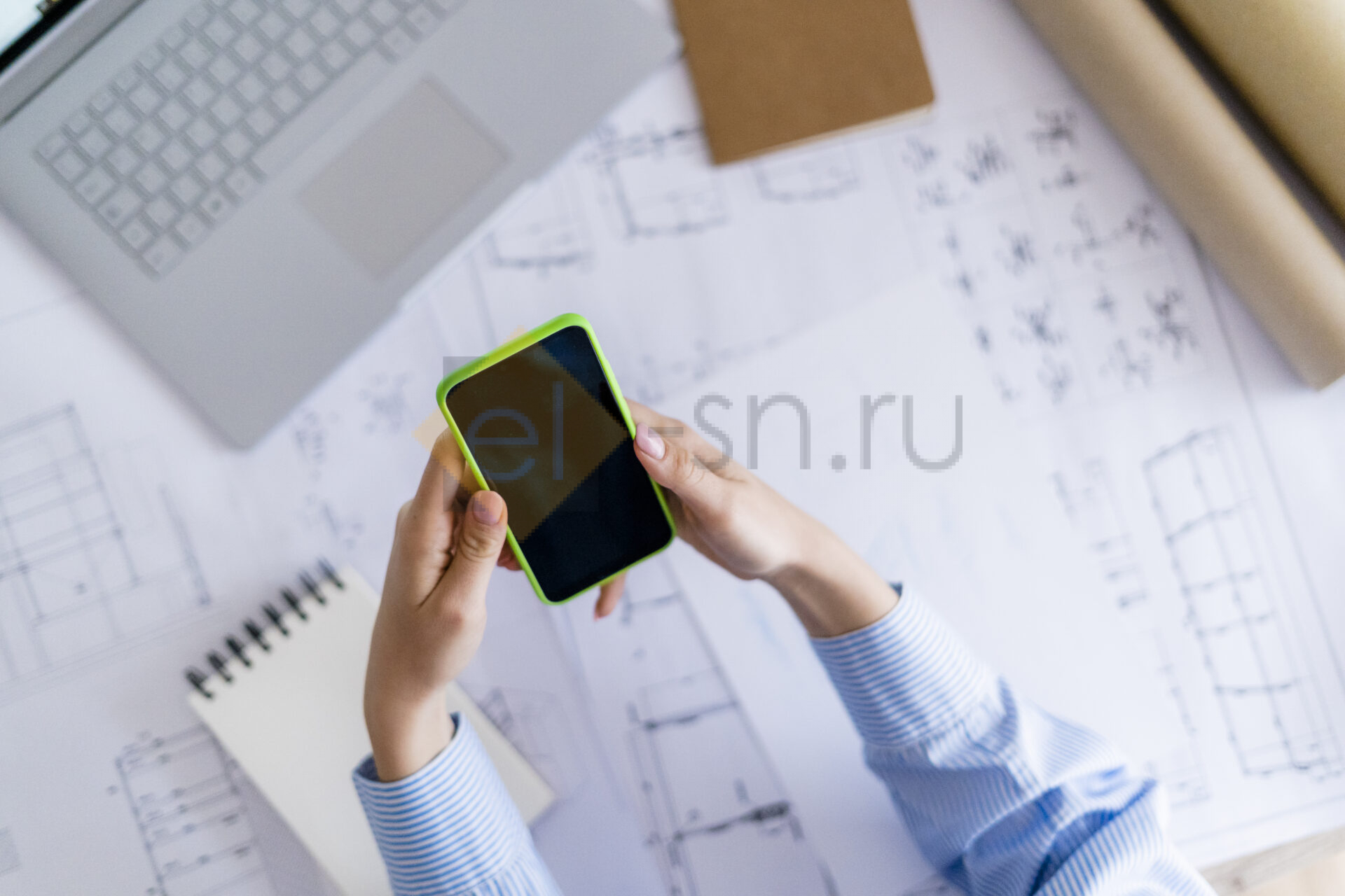Женщина в офисе работает с проектом на телефоне