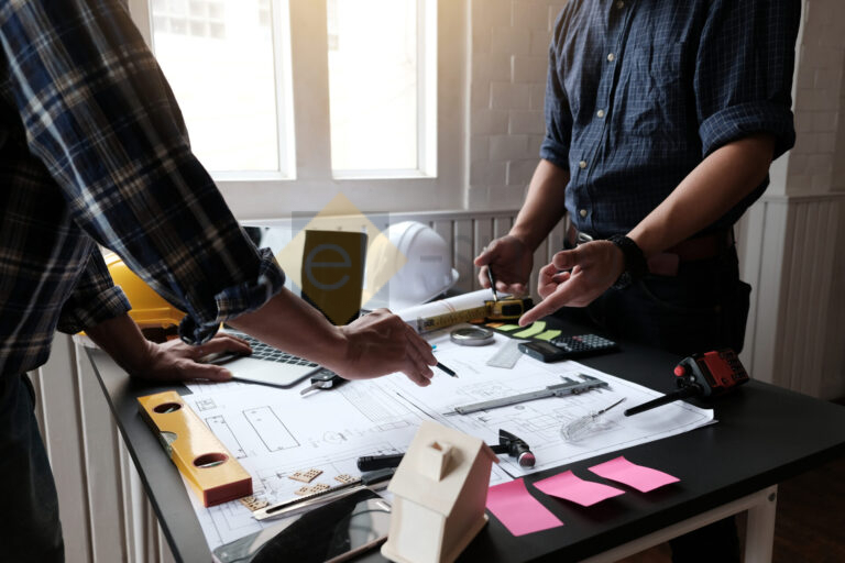 Два архитектора обсуждают проект за рабочим столом